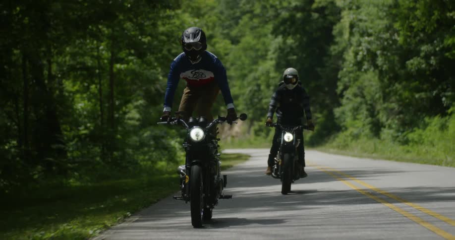 Motorcyclists ride on a rural road