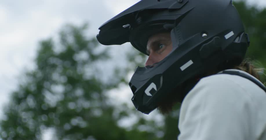 A motorcyclist wears a helmet outside