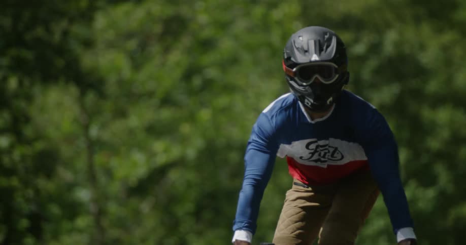 Man is standing while riding motorcycle on sunny day
