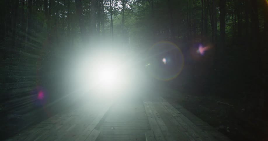 A motorcyclist rides over a wood bridge