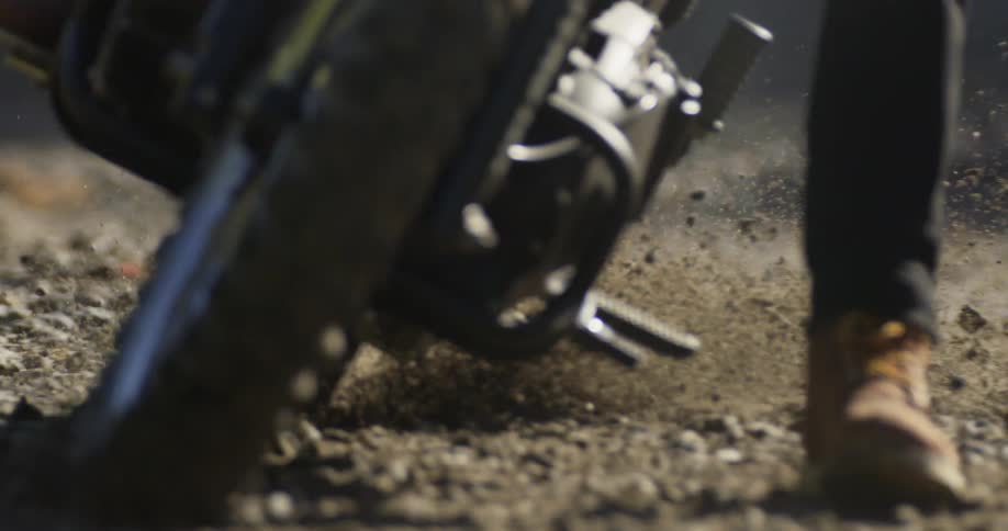 A motorcyclist rides over dirt