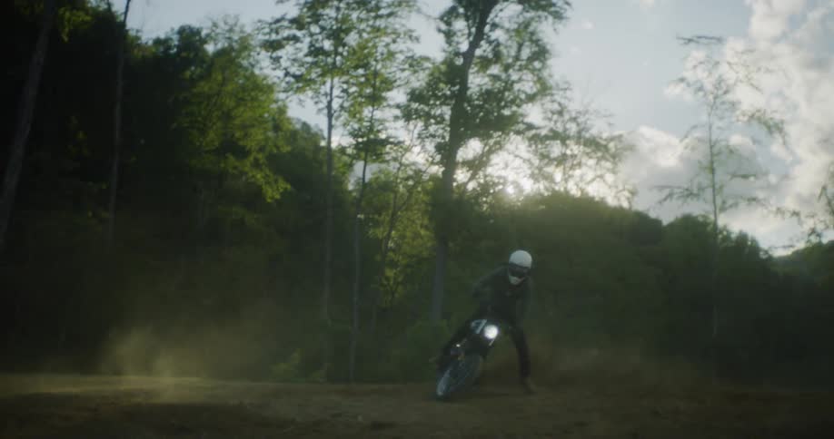 A man skids out on a dirt bike