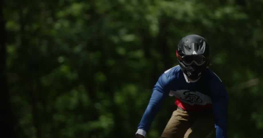 A man rides a motorcycle through the woods