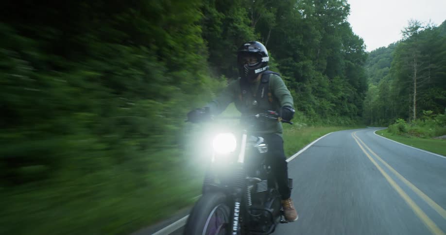 Man rides a motorcycle near the yellow lines on the road