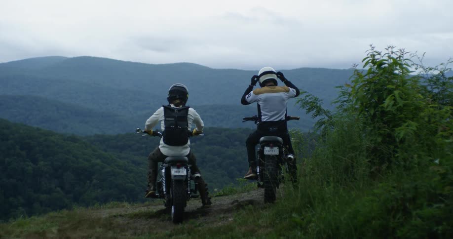 Motorcyclists stop to enjoy a mountain view