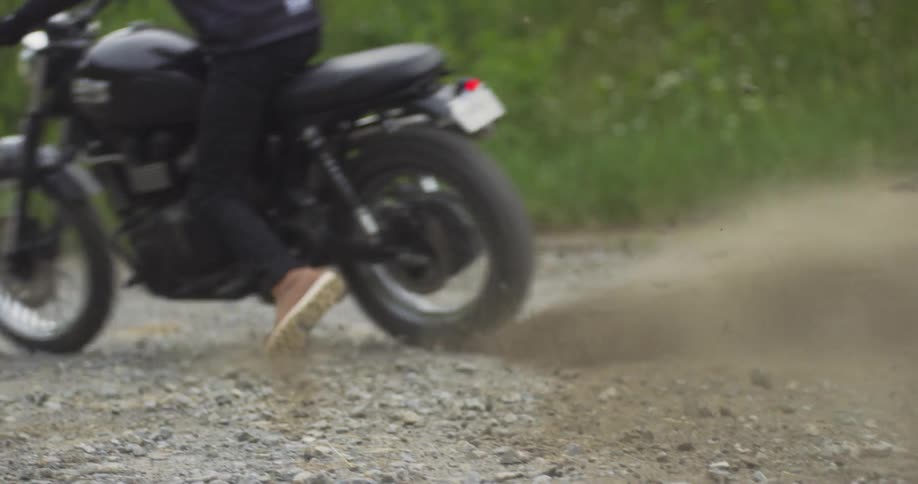 A rider kicks up dirt when taking off on a motorcycle