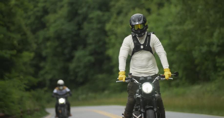 Two motorcyclists ride together on the road