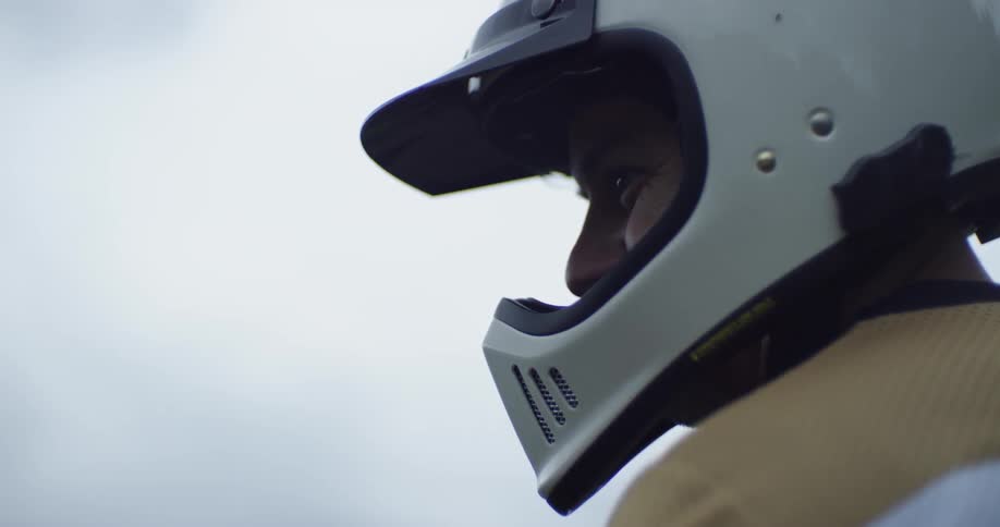 A motorcyclist wears a helmet outside