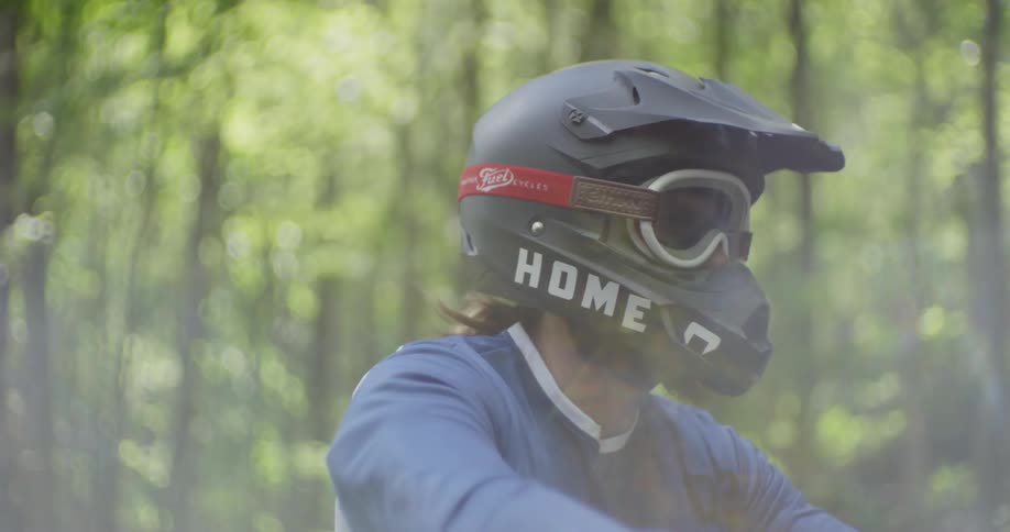 A motorcyclist rides in a forest