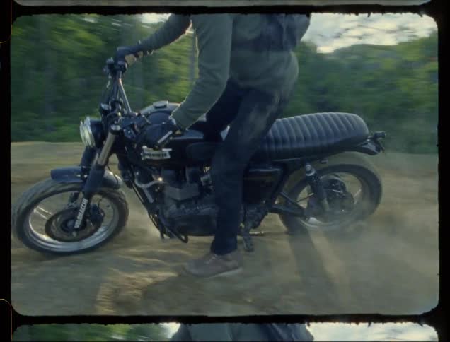 A motorcyclist kicks up dust while spinning in dirt