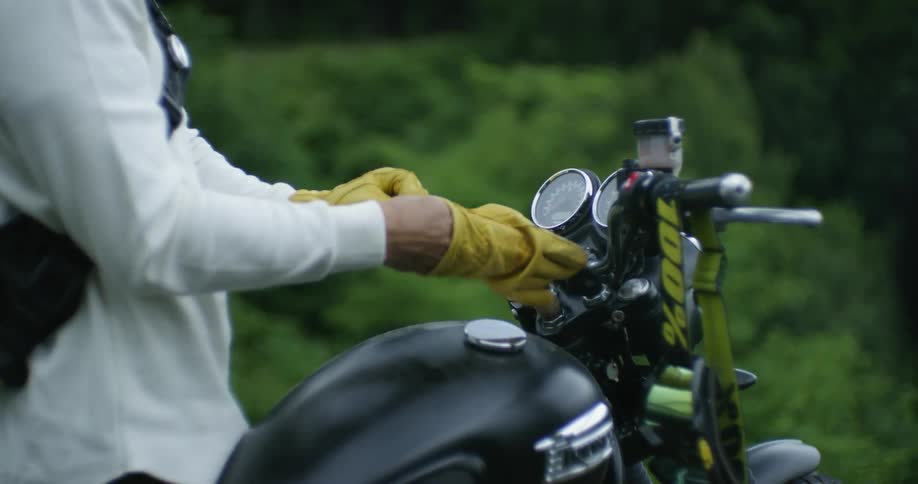 A motorcyclist puts on a pair of gloves