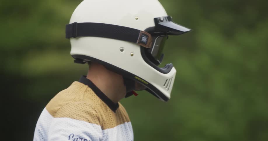 A man looks around in a white helmet