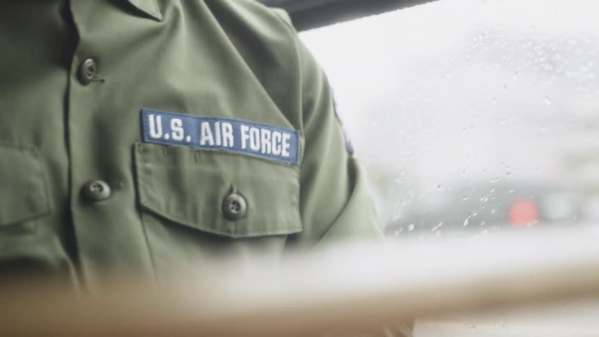 A service member rides a bus