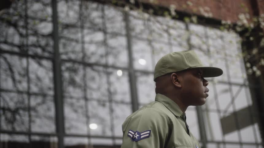 An airman standing in front of a building looks up