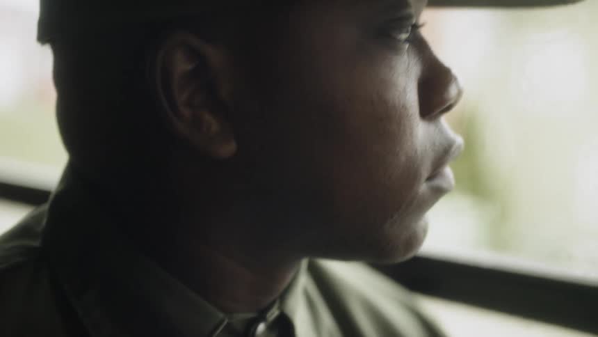 A man in uniform looks out the bus window