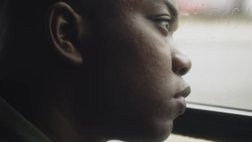 A man looks out the window of a bus or trolley