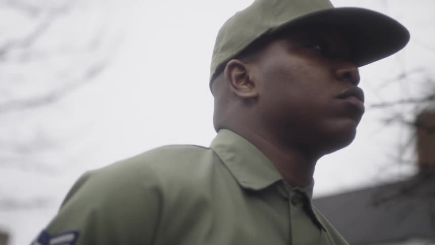 A soldier walks outside on an overcast day