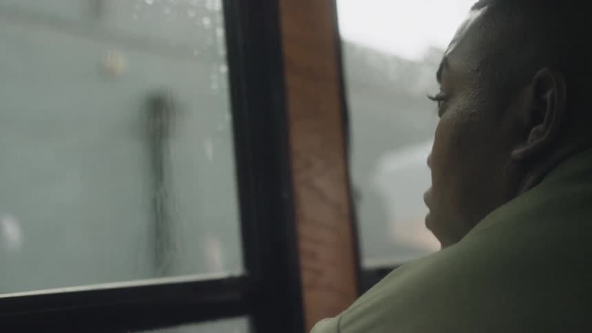 A soldier looks out of a bus window