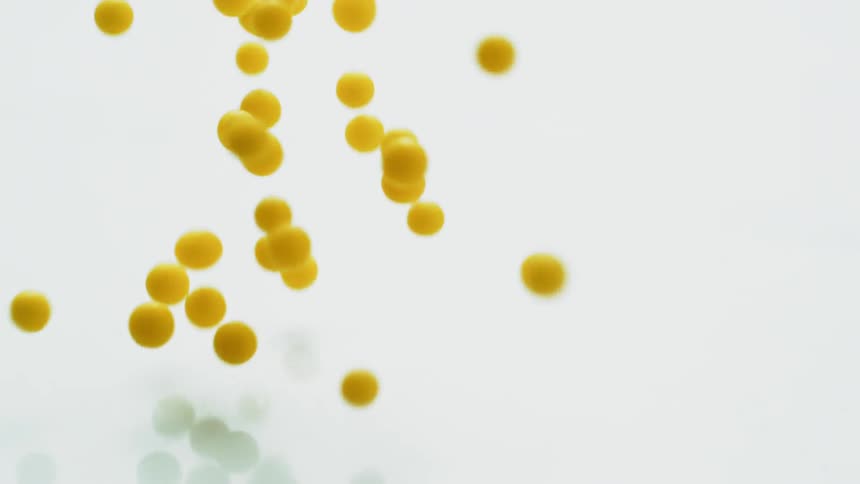 Yellow balls fall and bounce against a white surface