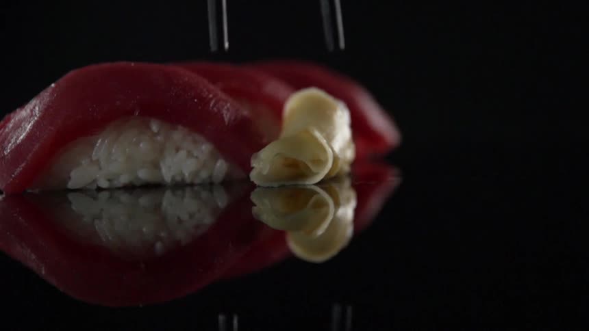 Pickled ginger is placed next to nigiri sushi