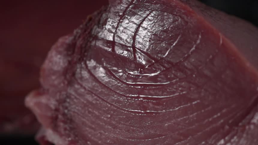 Tuna steak falls onto a table