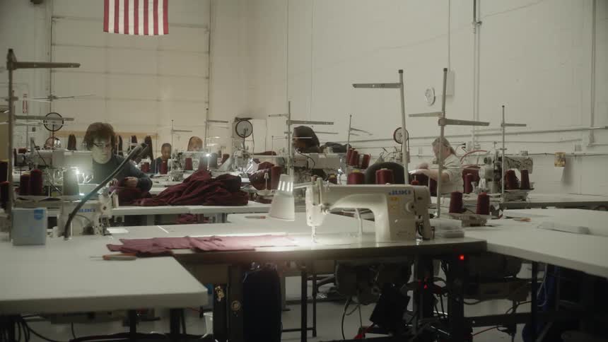 Several people in a room all working at sewing machines