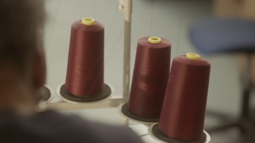 A woman works at a sewing table