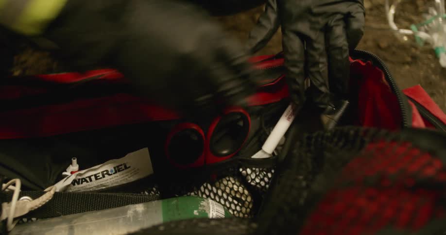 An emergency worker looks through a medical bag