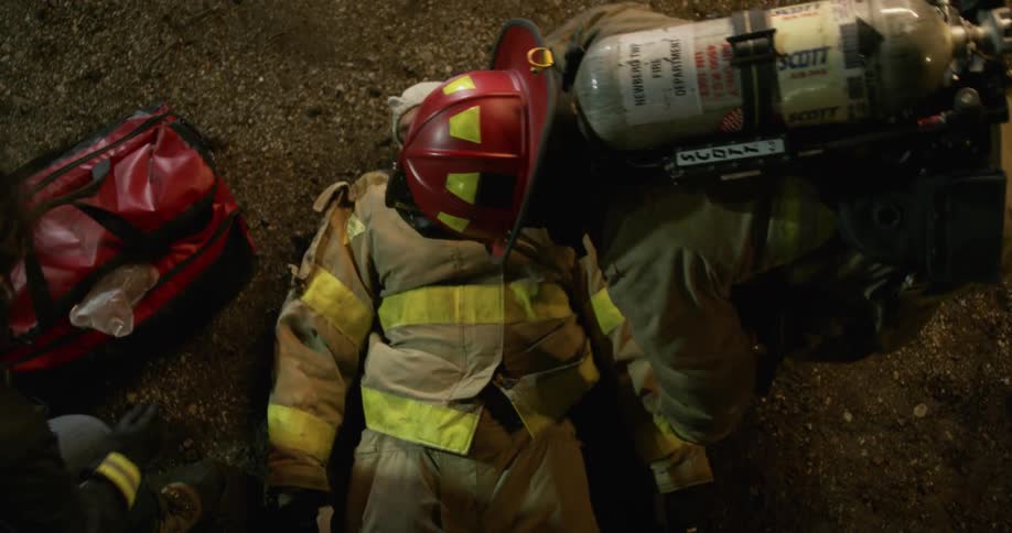 An injured firefighter is laid on the ground