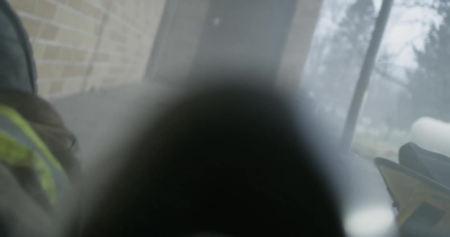 An injured firefighter is dragged from a burning building