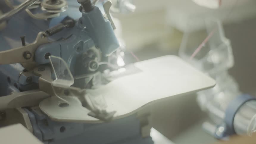 A person threads a sewing machine