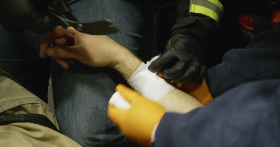 Man cuts a bandage with scissors
