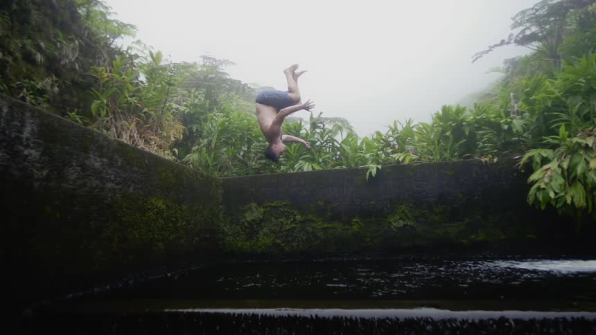 A man does a backflip into the water