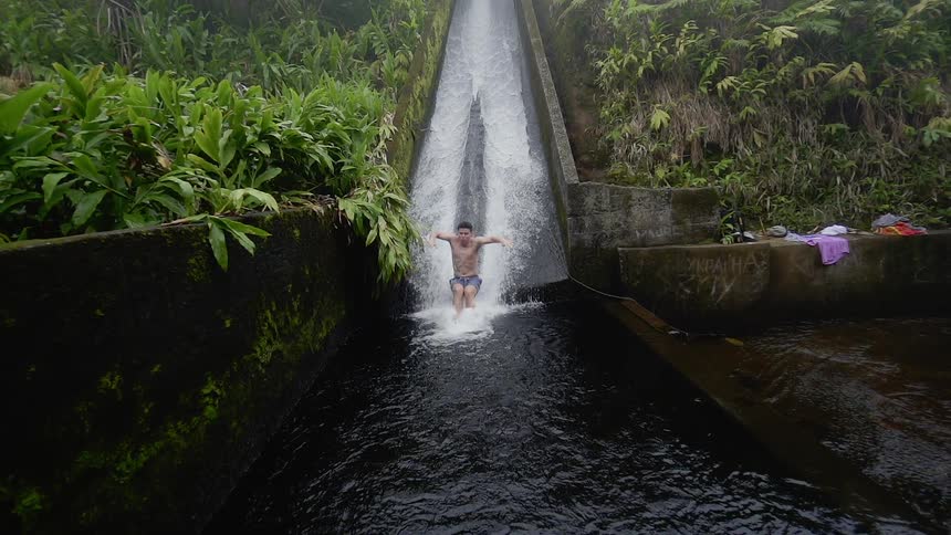 A man slides down the water splashing all over