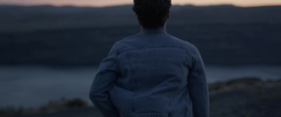 Man walks near river at dusk