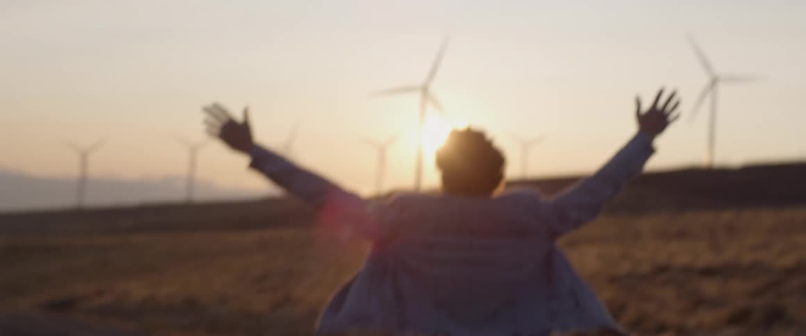 Man walks with outstretched arms towards the sunset