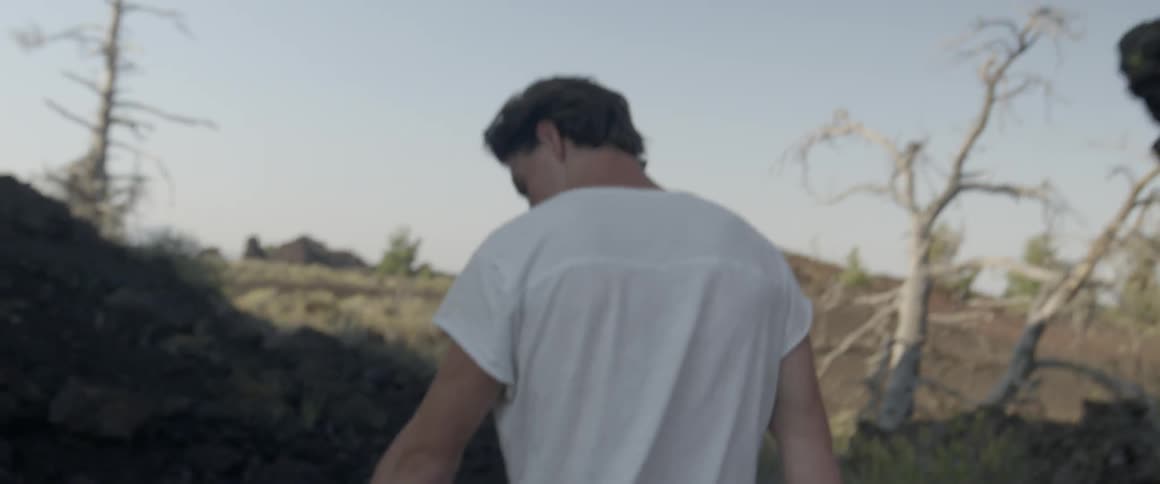 Man in a white shirt walks in a field