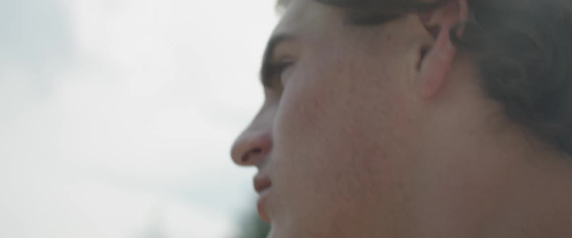 A young man looks around outside