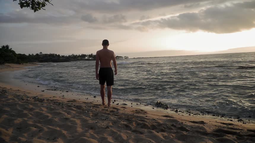 A man walks towards the water of the beach