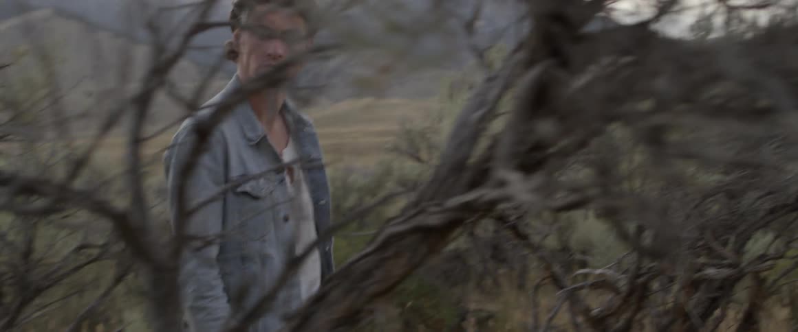 A man walks past the brush on the field