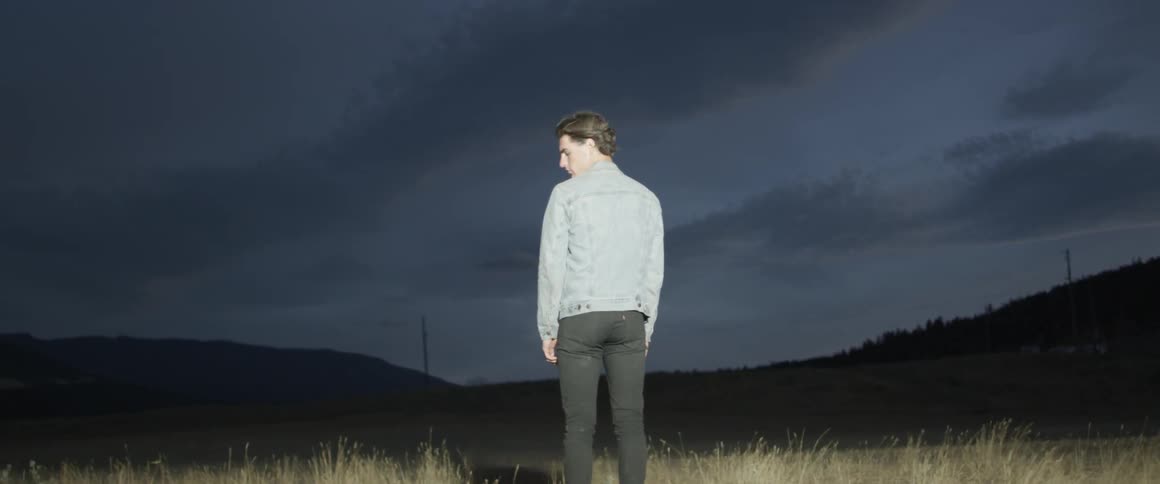 A man stands on the field at dawn
