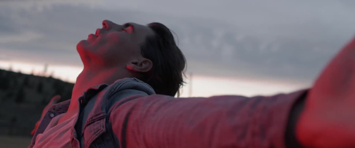 Man stretches his arms as he looks towards the sky