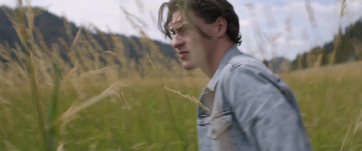 Man walks quickly in a field of tall weeds