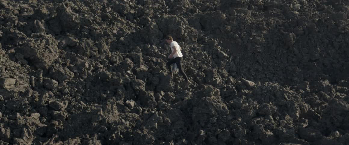 A man climbs up the rock hill