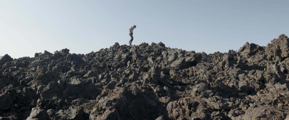 A person climbs over the rocks on a sunny day