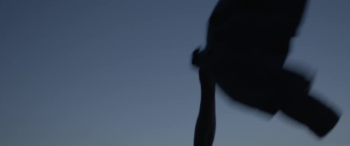 A man holds a jacket up into the breeze