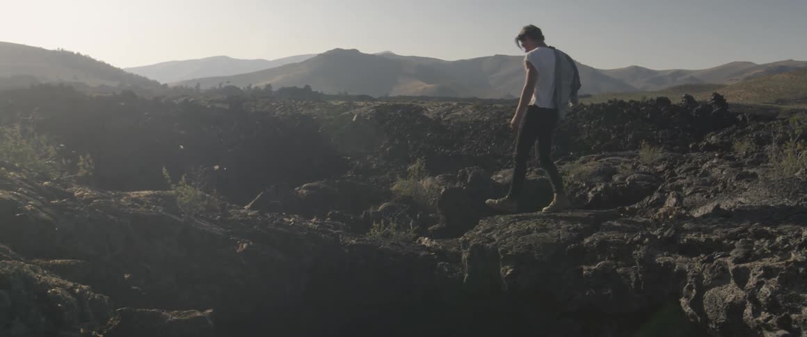 A man walks on the rocky terrain