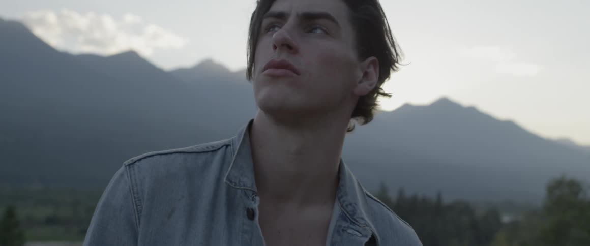 The man looks up at the sky on the field