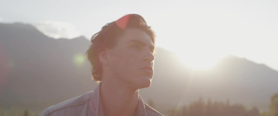 A man walks onto the field as the sun sets