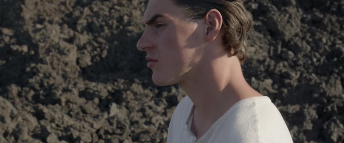A man looks around outside on a sunny day
